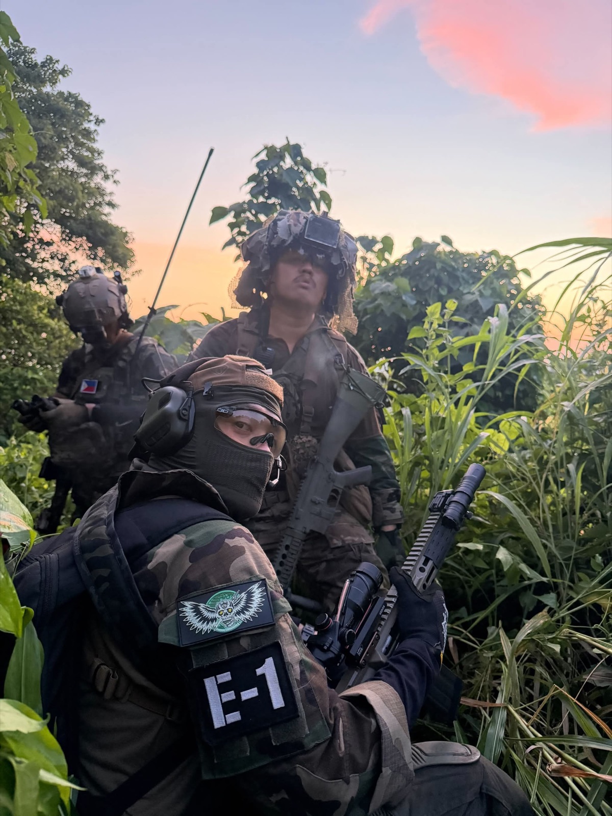 214 Foreign Legionnaires members staged in dense field vegetation during an airsoft event.
