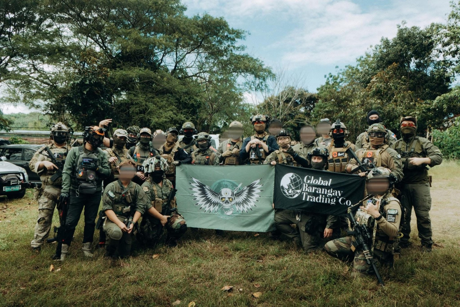 214 Foreign Legionnaires team members holding the team flag at an outdoor airsoft field.